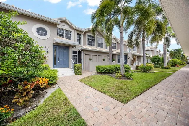a front view of a house with a garden and trees