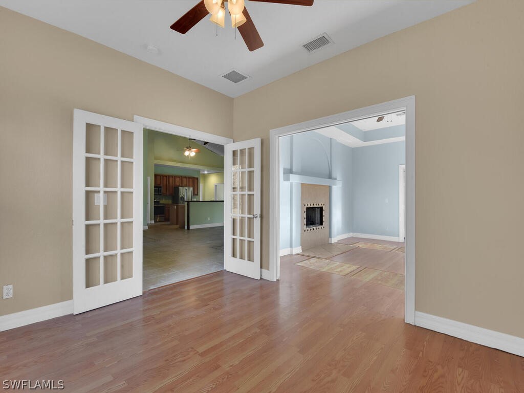 20401 Carter Road Estero, FL 33928 - Photo 16 of 42 an empty room with wooden floor chandelier and entryway