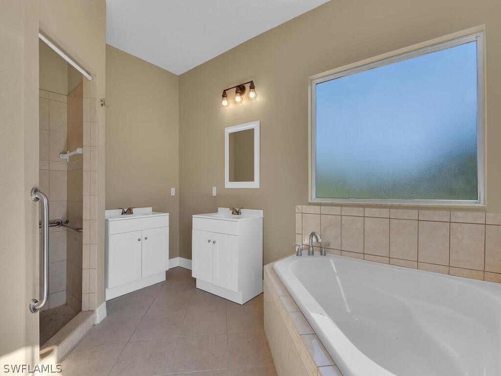 20401 Carter Road Estero, FL 33928 - Photo 20 of 42 a bathroom with a tub sink and mirror