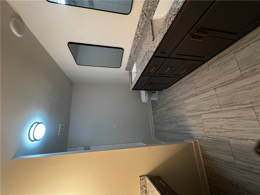 213 Carter Road Pottsville, AR 72858 - Photo 12 of 41 Bathroom featuring grey wood-finish LVP flooring and a dual vanity with granite countertops and undermount sinks. Also a bonus vanity area.