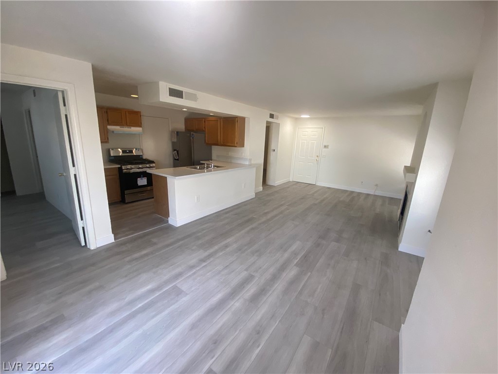 7570 West Flamingo Road, Unit 125 Las Vegas, NV 89147 - Photo 5 of 29 Unfurnished living room with light wood-type flooring and baseboards