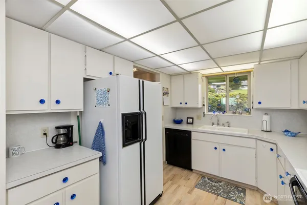 a kitchen with a sink a refrigerator and cabinets