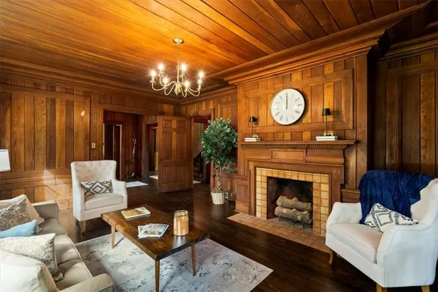 a living room with furniture a clock and a fireplace