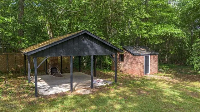 a view of a house with a small yard and wooden fence