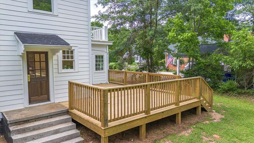 6104 Floyd Street Northeast Covington, GA 30014 - Photo 44 of 53 a view of a white house with a wooden deck and a backyard