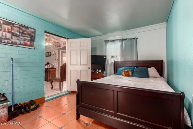 a bedroom with a bed and a painting on the wall