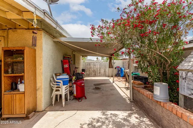 a view of a patio with table and chairs potted plants and a large tree