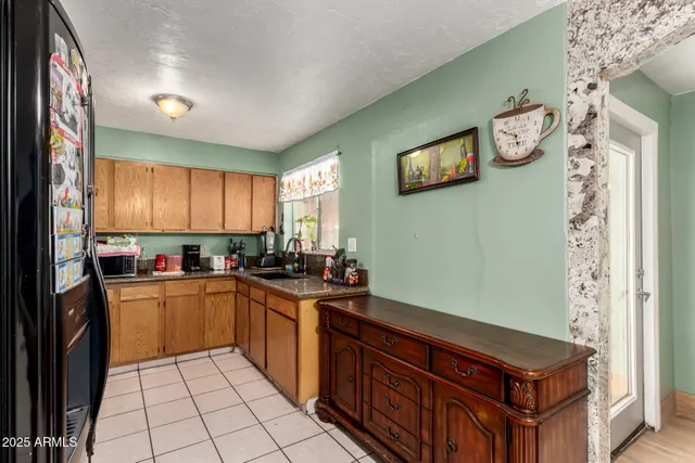 a kitchen with stainless steel appliances kitchen island granite countertop a refrigerator and a sink