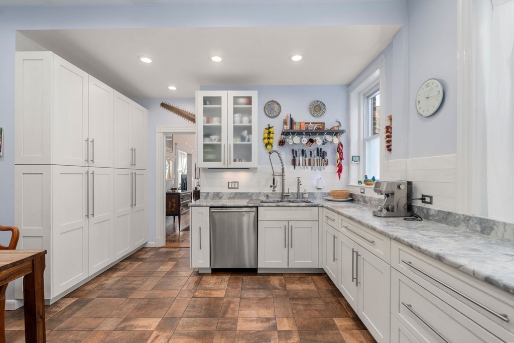7 Parkman Street, Unit 1 Brookline, MA 02446 - Photo 14 of 27 a large white kitchen with stainless steel appliances granite countertop a sink and a window