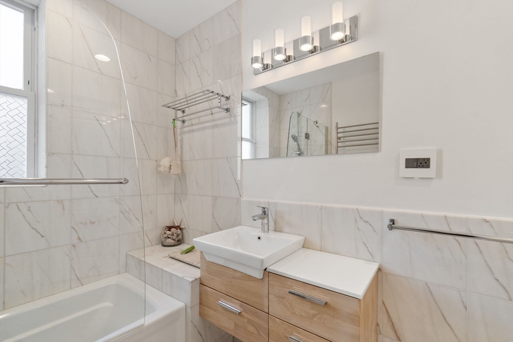 7 Parkman Street, Unit 1 Brookline, MA 02446 - Photo 22 of 27 a bathroom with a bathtub a sink and a mirror