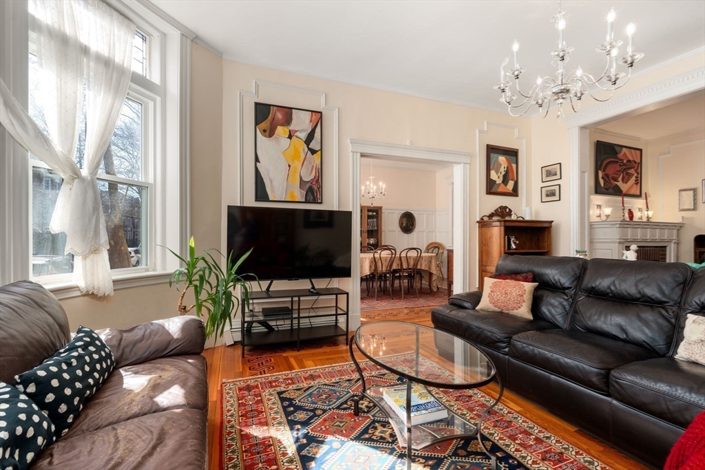 7 Parkman Street, Unit 1 Brookline, MA 02446 - Photo 7 of 27 a living room with furniture a flat screen tv and a large window