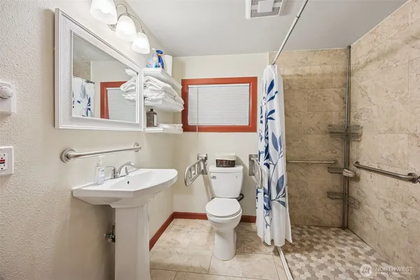 a bathroom with a sink toilet and shower