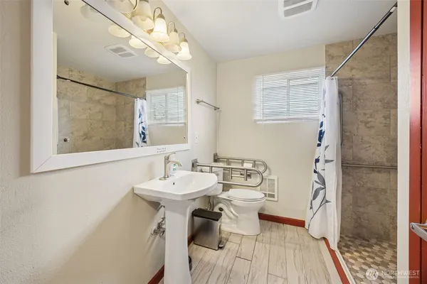 a bathroom with a sink a toilet and shower