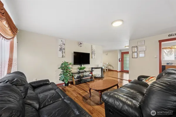 a living room with furniture a flat screen tv and a window