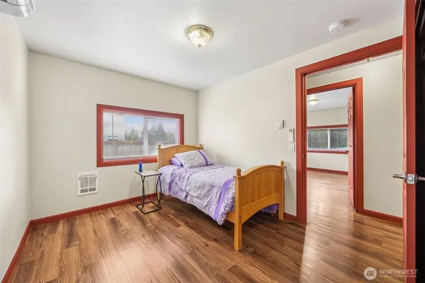 a bedroom with a bed and wooden floor
