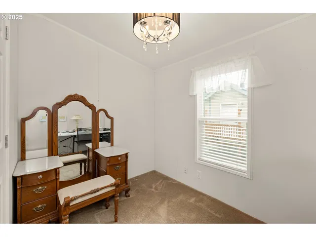 a view of a workspace room with furniture and window