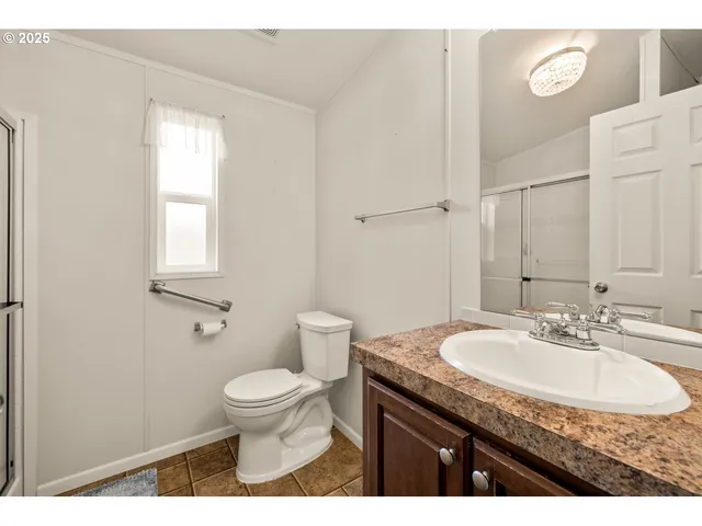 a bathroom with a granite countertop sink a toilet and a mirror