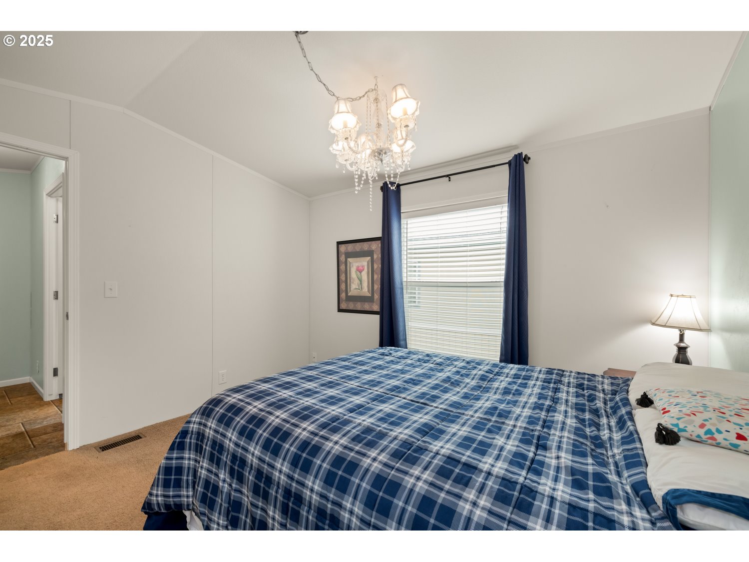 2696 Southeast Palmquist Road Gresham, OR 97080 - Photo 15 of 21 a bedroom with a bed and a chandelier