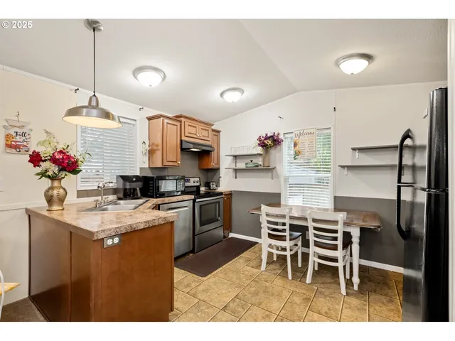 a kitchen with a table chairs refrigerator and cabinets