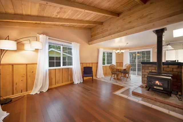 a living room with furniture floor to ceiling window and wooden floor