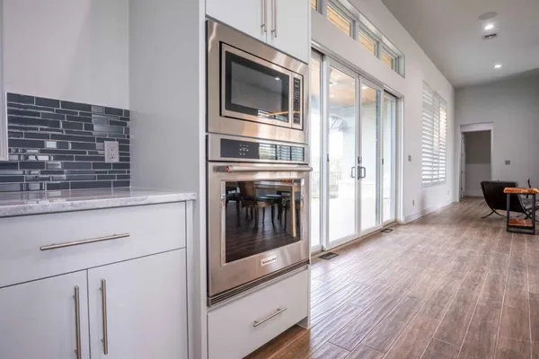 a kitchen with stainless steel appliances wooden floor sink and wooden cabinets