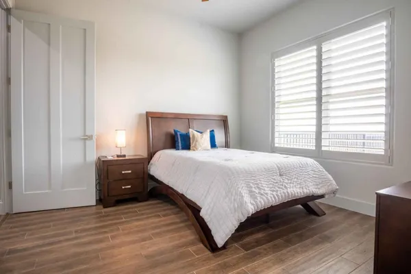 a spacious bedroom with a bed and wooden floor