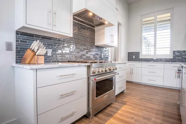 a kitchen with granite countertop white cabinets and white appliances