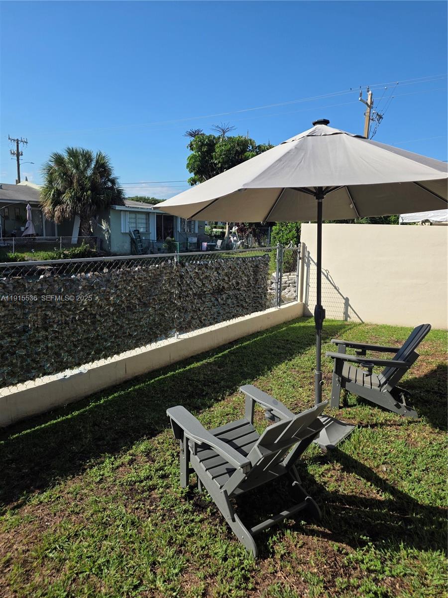 10110 Southwest 20th Street Miami, FL 33165 - Photo 17 of 20 a view of a wooden deck with furniture and umbrella
