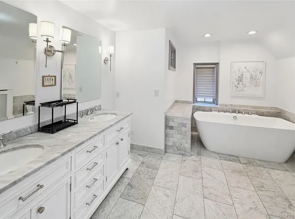 a spacious bathroom with a double vanity sink mirror and bathtub