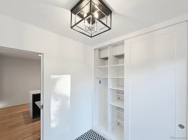 a view of a hallway with wooden floor and closet