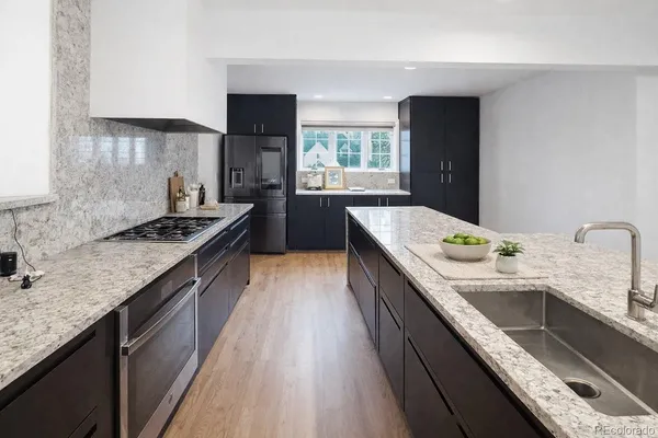 a kitchen with granite countertop sink stove and cabinets