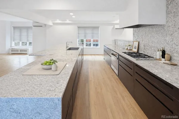 a large kitchen with stainless steel appliances granite countertop a lot of counter space and wooden floor