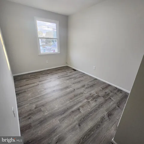 a view of a room with wooden floor and white walls