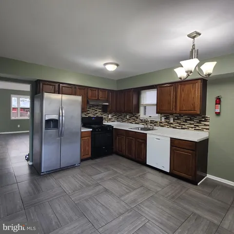 a kitchen with a refrigerator a sink and cabinets