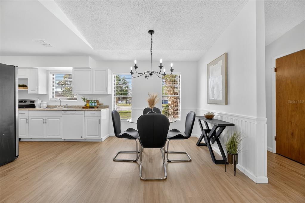 13035 Santee Street Spring Hill, FL 34609 - Photo 14 of 39 a kitchen with a refrigerator and white cabinets