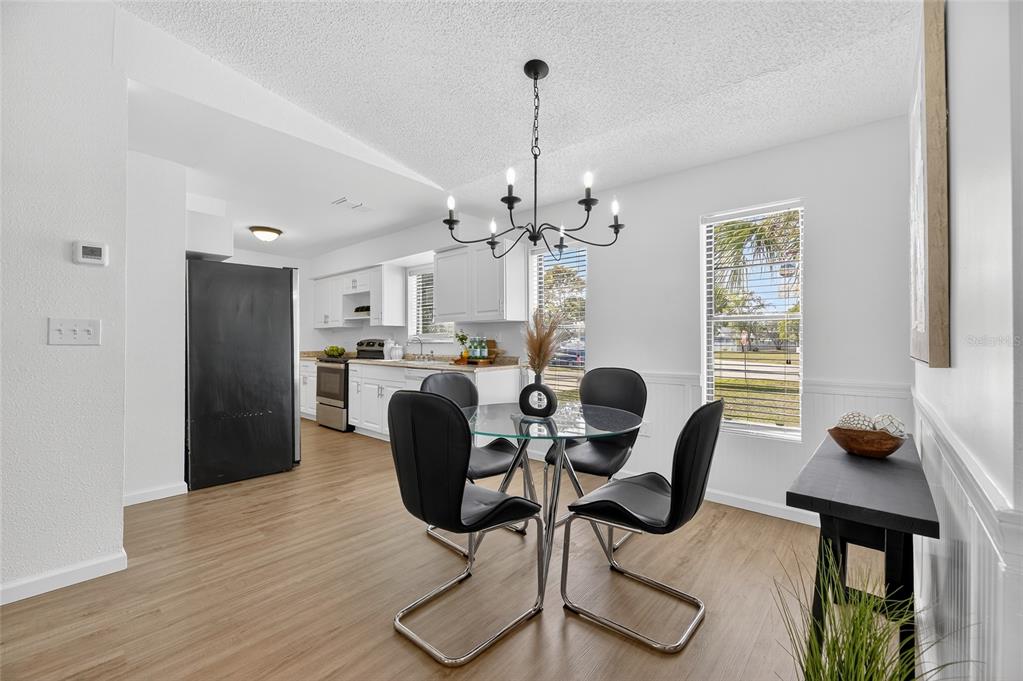 13035 Santee Street Spring Hill, FL 34609 - Photo 15 of 39 a view of a dining room with furniture a chandelier and wooden floor