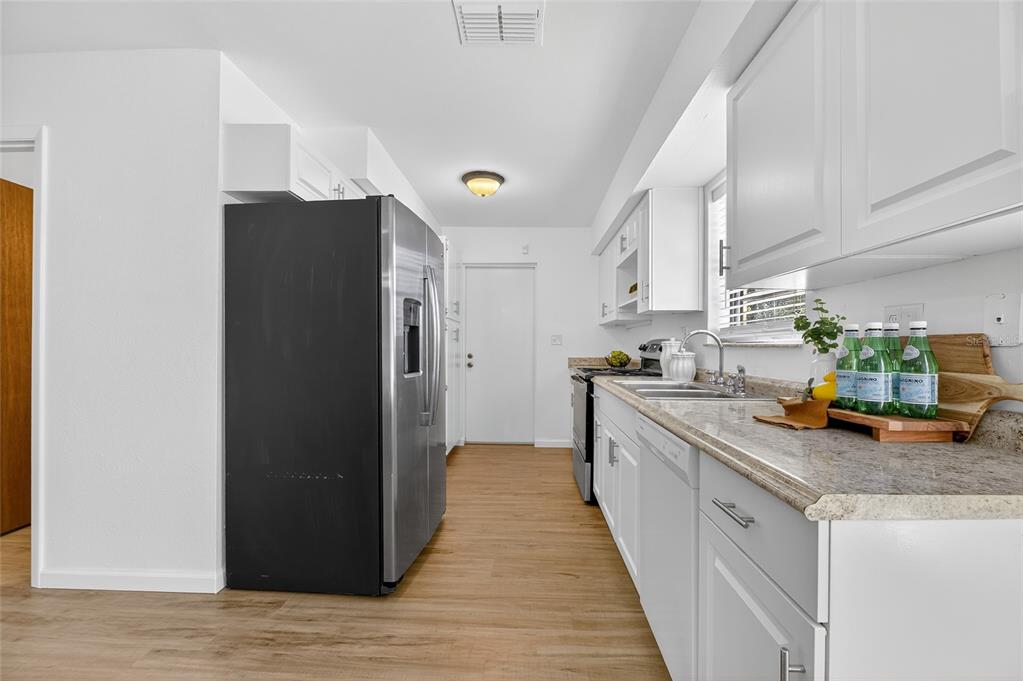 13035 Santee Street Spring Hill, FL 34609 - Photo 17 of 39 a kitchen with stainless steel appliances granite countertop a refrigerator a stove and a sink