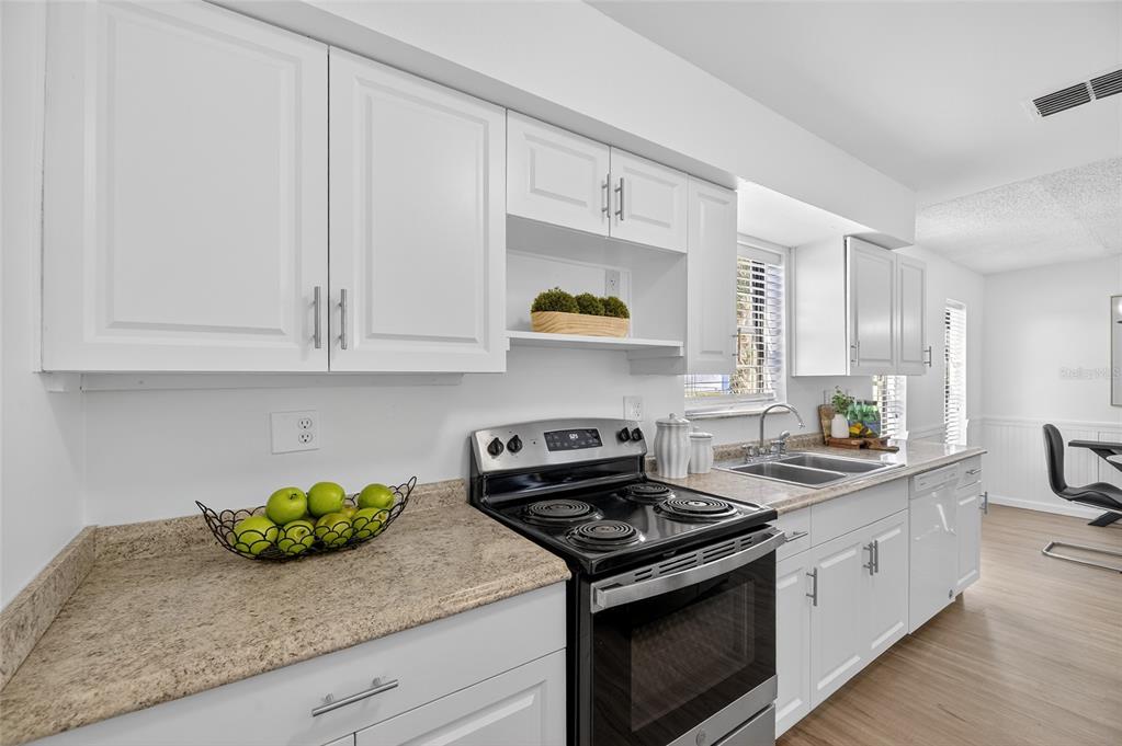 13035 Santee Street Spring Hill, FL 34609 - Photo 19 of 39 a kitchen with stainless steel appliances granite countertop white cabinets and a stove