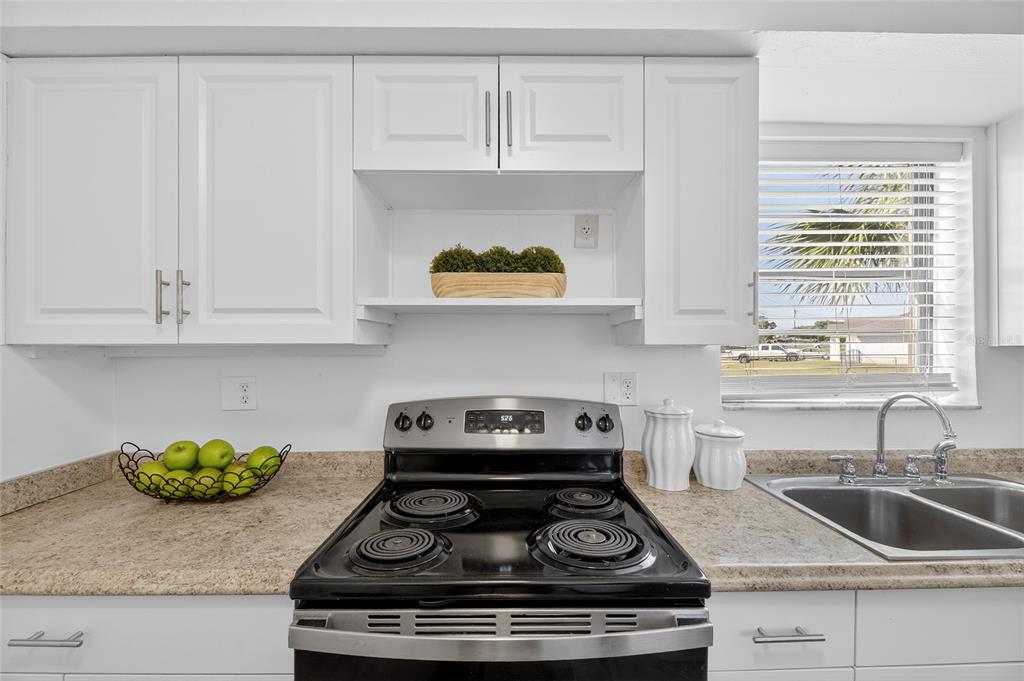 13035 Santee Street Spring Hill, FL 34609 - Photo 21 of 39 a kitchen with stainless steel appliances granite countertop white cabinets white stove and a granite counter tops