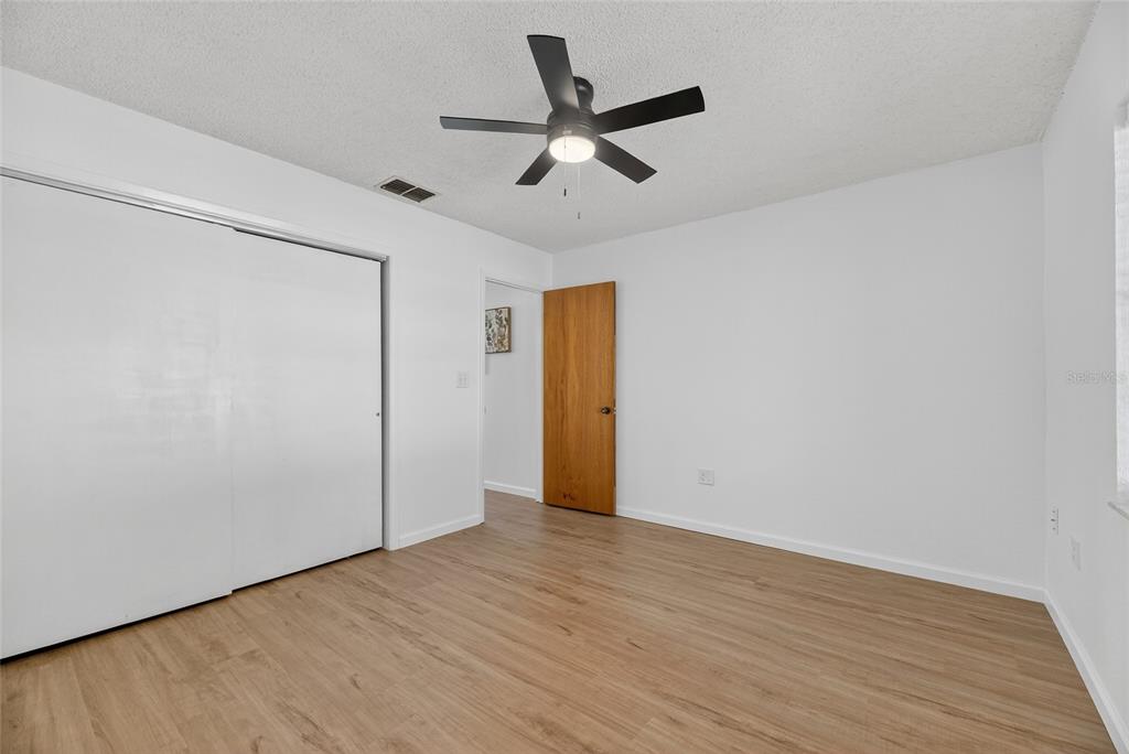 13035 Santee Street Spring Hill, FL 34609 - Photo 25 of 39 an empty room with wooden floor and ceiling fan