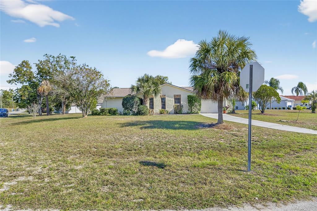 13035 Santee Street Spring Hill, FL 34609 - Photo 33 of 39 a view of a house with a yard and palm trees