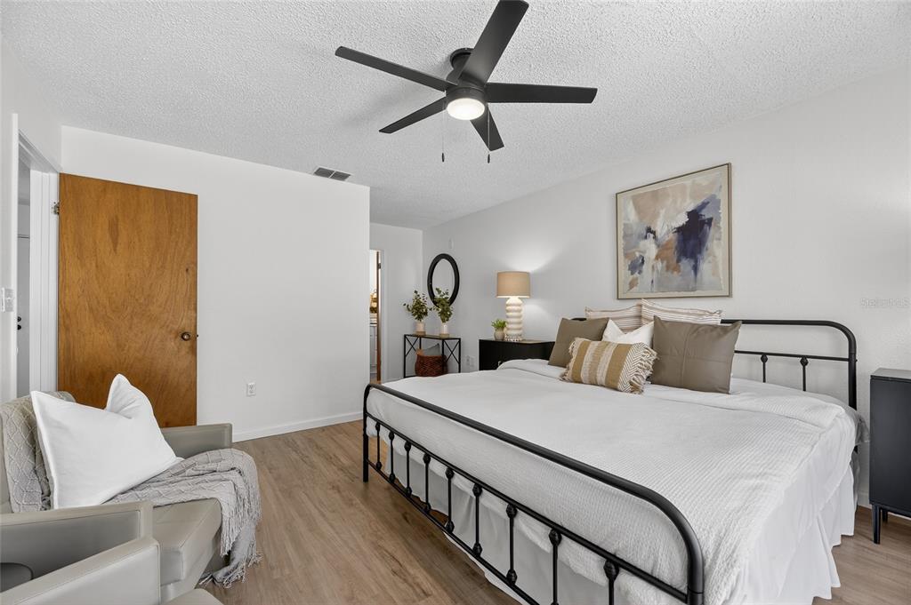 13035 Santee Street Spring Hill, FL 34609 - Photo 10 of 39 a bedroom with a bed and a chandelier