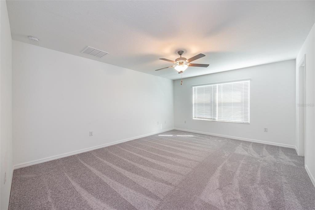 14348 Editors Note Street Ruskin, FL 33573 - Photo 19 of 29 a view of an empty room with a chandelier fan