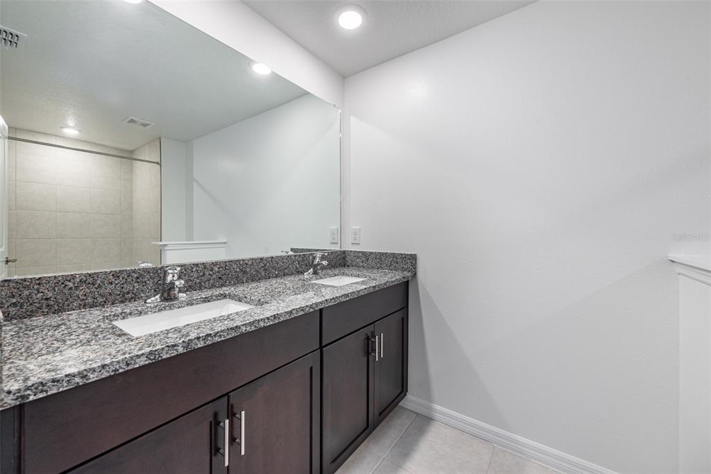 14348 Editors Note Street Ruskin, FL 33573 - Photo 20 of 29 a bathroom with a granite countertop sink and a mirror