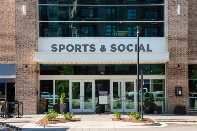 a view of a building with a yard and sitting area