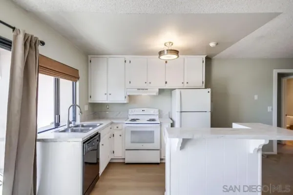 a kitchen with white cabinets and white appliances