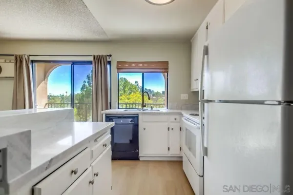 a large white kitchen with a large window