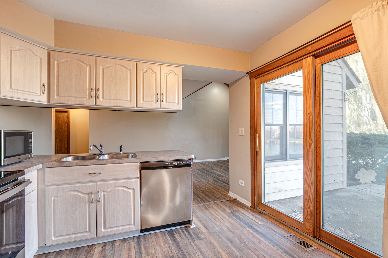 663 Beth Court Gurnee, IL 60031 - Photo 8 of 26 a kitchen with white cabinets and a window