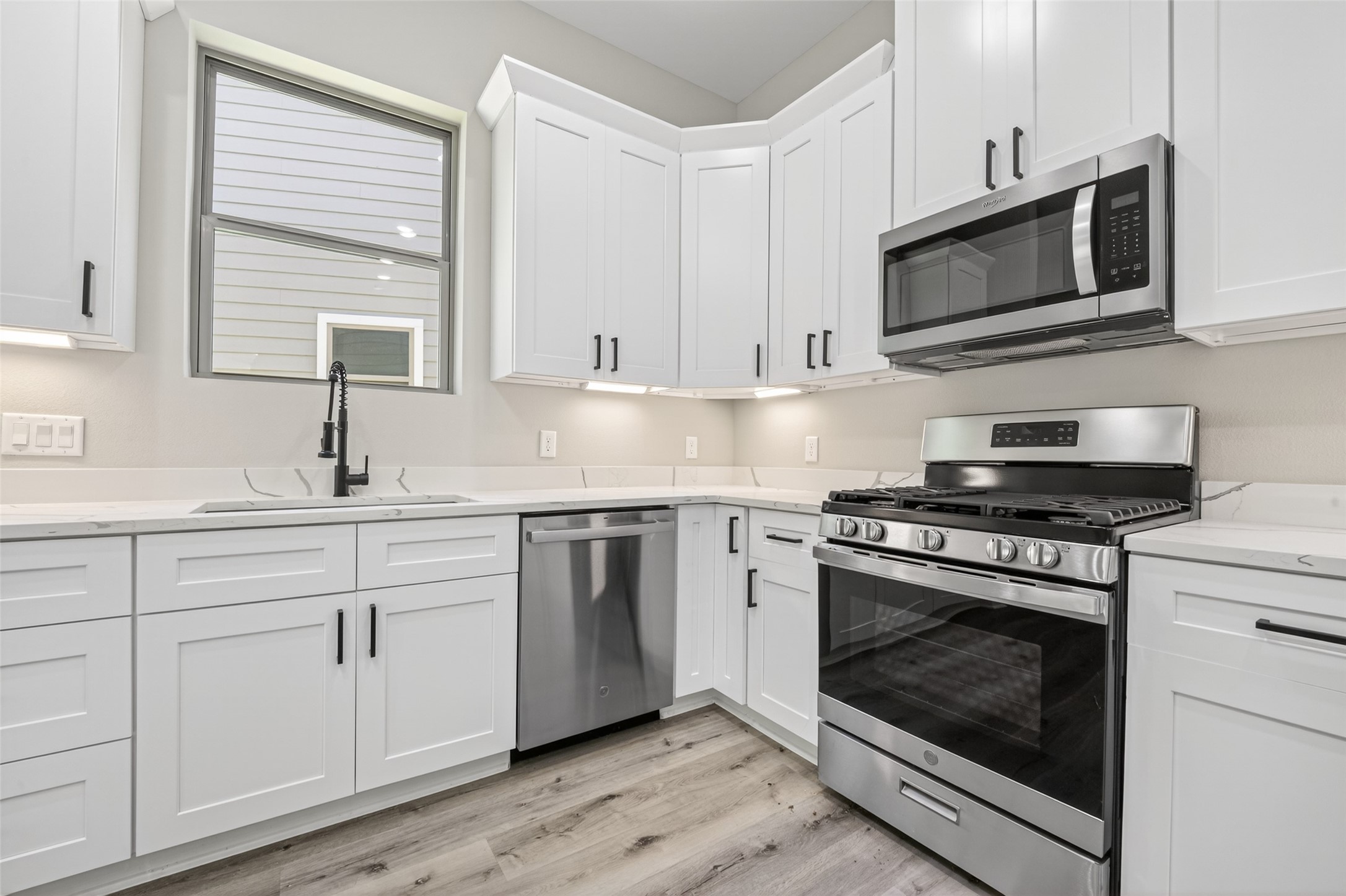 4906 Wunder Way Houston, TX 77069 - Photo 12 of 44 a kitchen with stainless steel appliances granite countertop a sink a stove and microwave