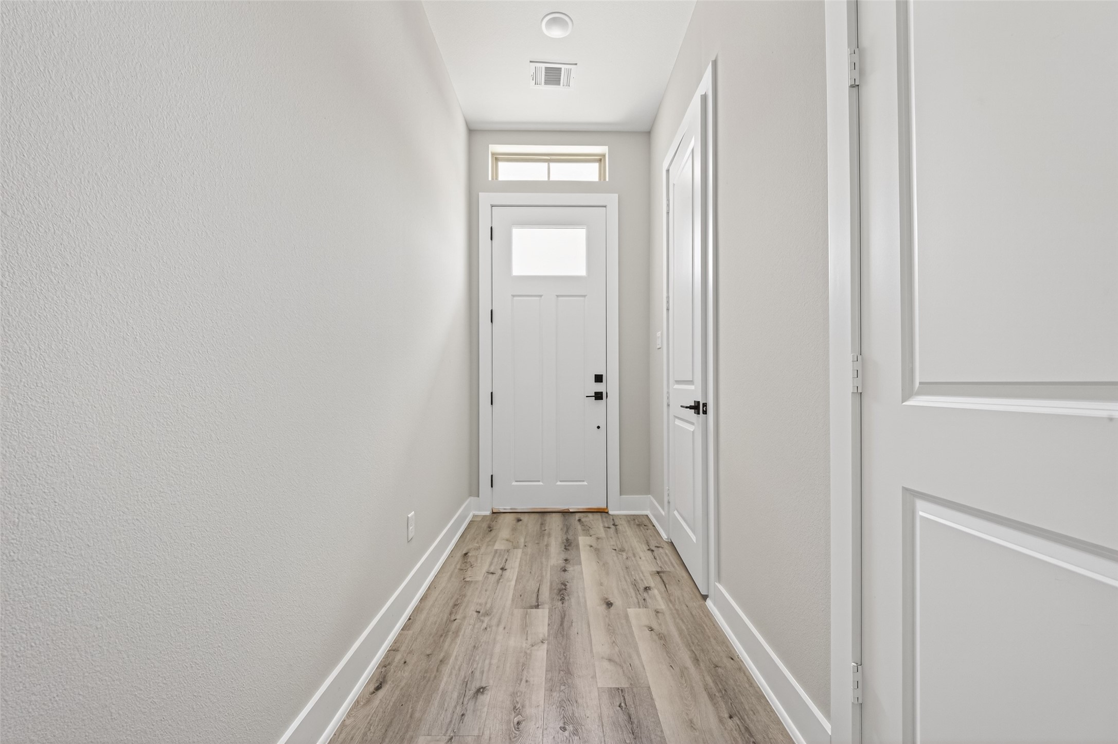 4906 Wunder Way Houston, TX 77069 - Photo 2 of 44 a view of a hallway with wooden floor and a bathroom